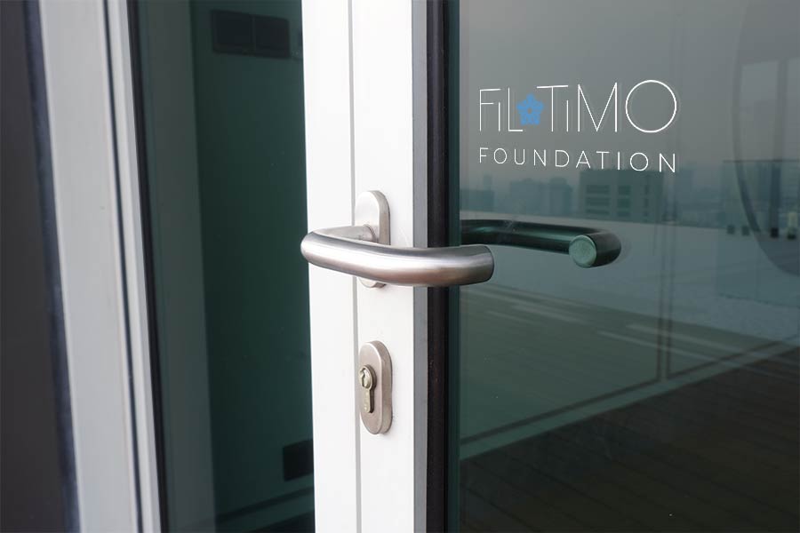 Photo of entrance doors with Filotimo logo on glass