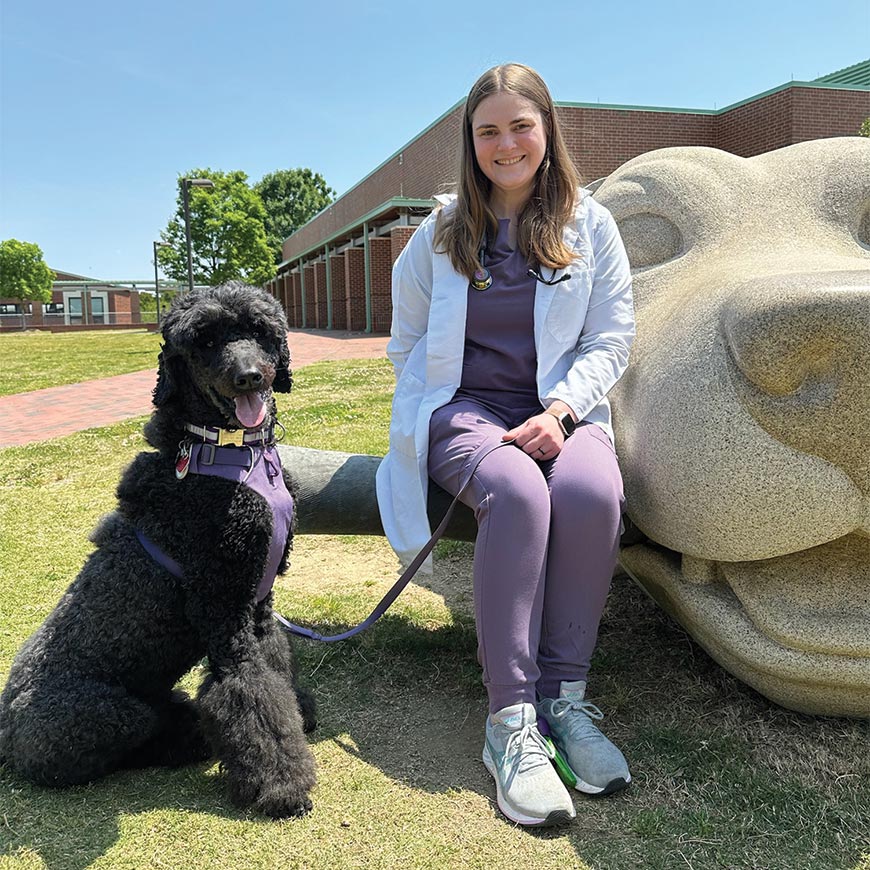 Photo of Anna and her dog outside the vet school