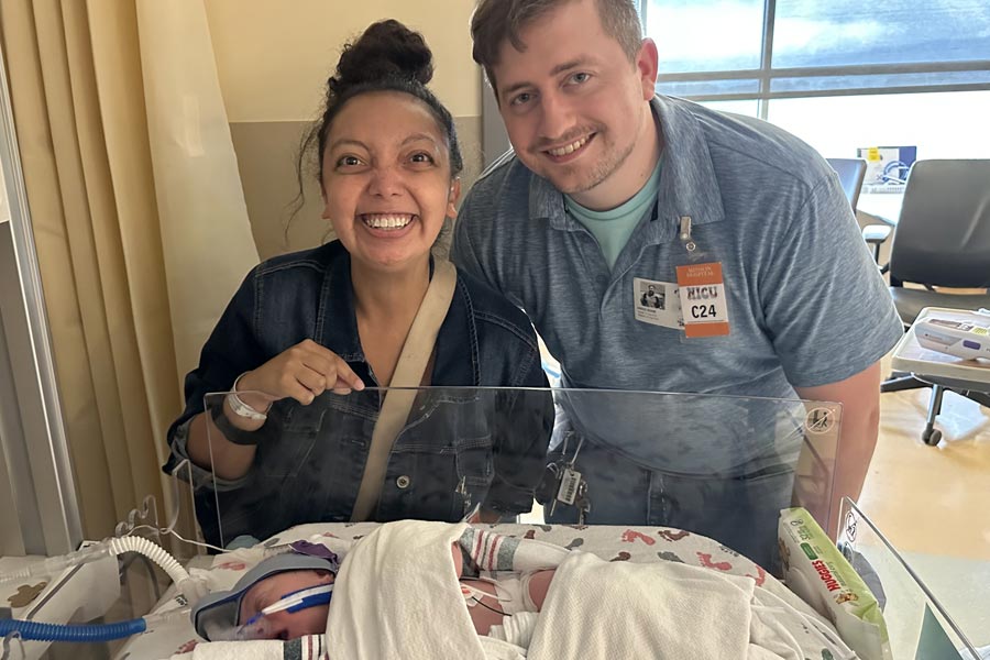 Photo of Nicole with her husband and baby